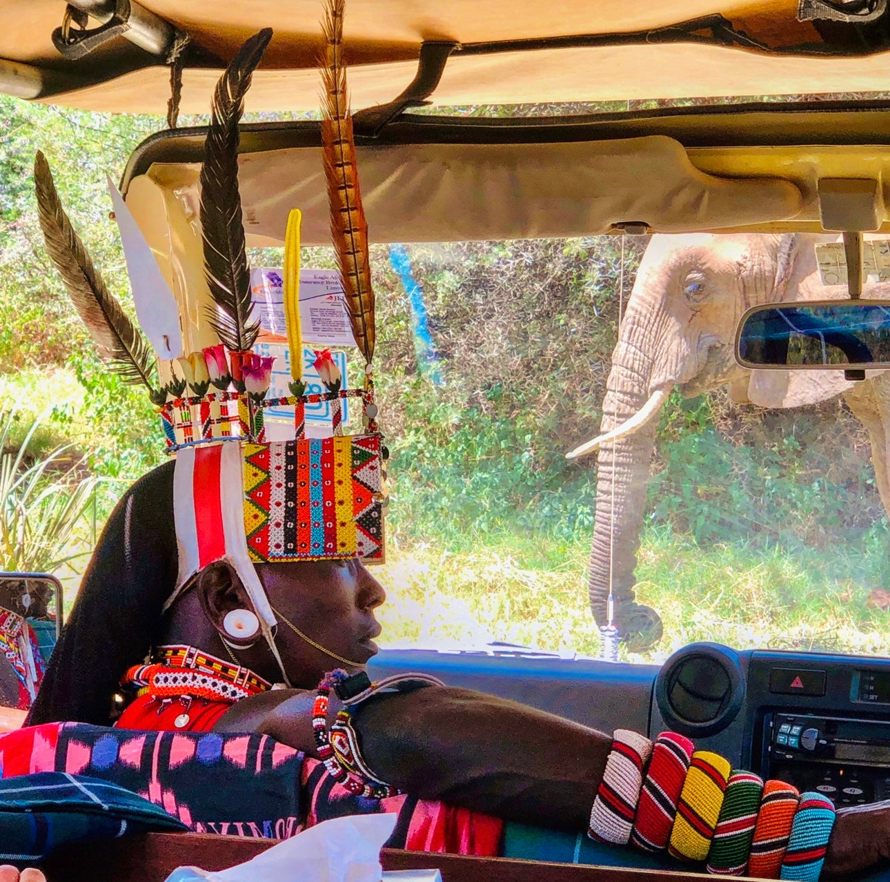 African man on safari wearing bright with beaded headwear and braclets