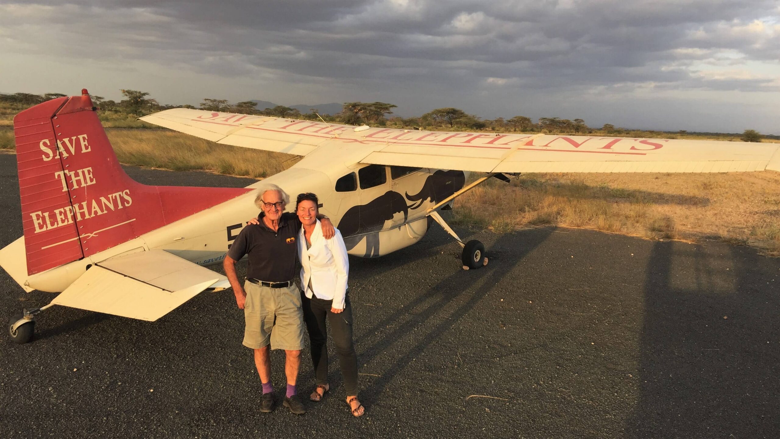 Lori Souder, Safari Specialist standing in front of an aircraft with Dr. Iain Douglas-Hamilton